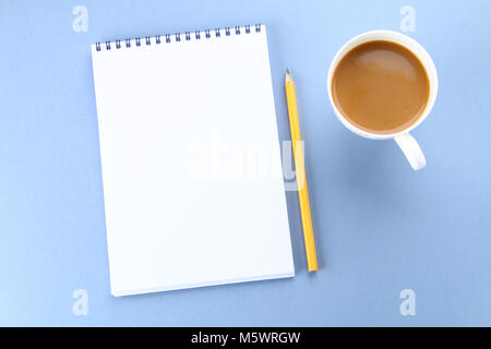 Top view image of open notebook with blank pages and coffee on blue background, ready for adding or mock up. Still life, business, office supplies or  Stock Photo