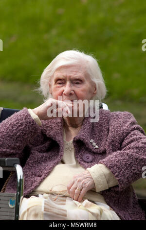 elderly lady with dementia sitting in wheelchair in park Stock Photo