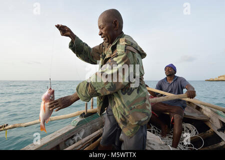 A year after Hurricane Matthew ravaged parts of Haiti, Marcilien Georges pulls in a fish in a small fishing boat off the coast of northwestern Haiti. Stock Photo
