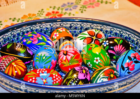 Colorful Hand Painted Wooden Easter Eggs in a Ceramic Bowl Stock Photo
