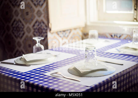 Table in Portuguese restaurant with traditional tiles ready for four people Stock Photo