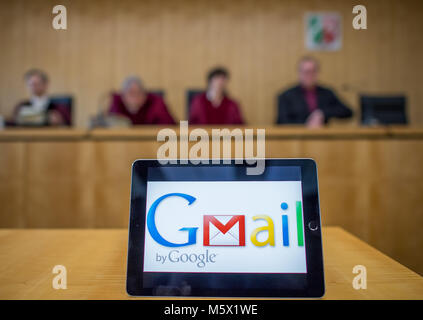 ILLUSTRATION - 26 February 2018, Germany, Muenster: An iPad with the logo of the Google service Gmail stands on a table at the Higher Adrministrative Court. The court negotiates the dispute between Google and the the German Federal Network Agency (BNetzA). After a notice from 2012, Google has to register its E-Mail service Gmail as telecommunication service. This would have consequences for data protection requirements and observation interfaces for German authorities. Google sued against this but lost the case in the first instance in front of the Administrative court Cologne. Photo: Guido Ki Stock Photo