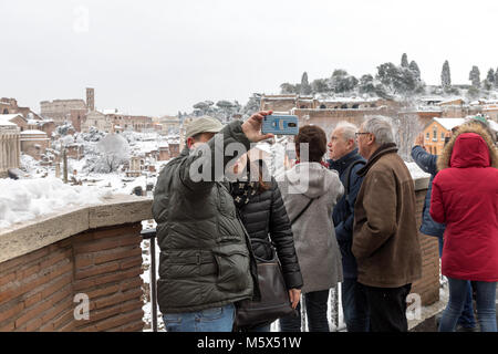Rome, Italy. 26th Feb, 2018. An exceptional weather event causes a cold and cold air across Europe, including Italy. Snow comes in the capital, covering streets and monuments of a white white coat. In the picture, some people take a selfie on the background of the Roman Forum covered with snow. Credit: Polifoto/Alamy Live News Stock Photo