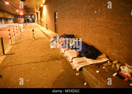 27 February 2018, Germany, Cologne: A homeless person sleeps in an underpass at icy temperatures. Photo: Henning Kaiser/dpa Stock Photo