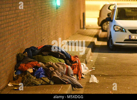 27 February 2018, Germany, Cologne: A homeless person sleeps in an underpass at icy temperatures. Photo: Henning Kaiser/dpa Stock Photo