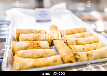 Closeup of fried greasy spring rolls on tray display in restaurant, fast food, unhealthy chinese cuisine Stock Photo