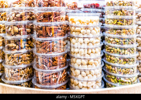 Many packaged seeds, nuts, dried in plastic containers on display on store shop shelves, macadamia, roasted, pistachios shelled, pecans, brazil, walnu Stock Photo