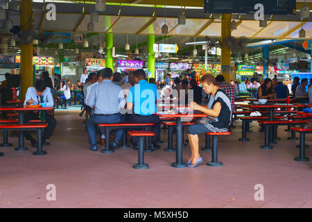 SINGAPORE - JAN 16, 2017 : People at food court in Singapore. Inexpensive food stalls are numerous in the city so most Singaporeans dine out at least  Stock Photo