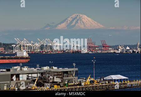 WA13729-00...WASHINGTON - View of Mt Rainier, Elliott Bay and the cranes for loading and unloading the container ships on the Seattle Waterfront. 2017 Stock Photo