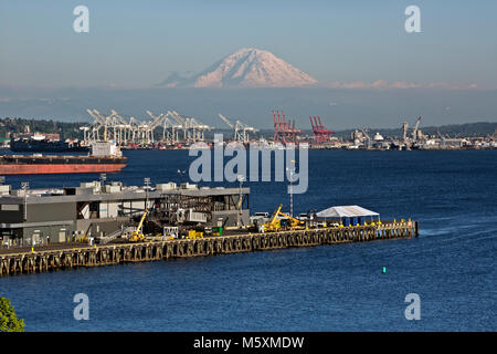 WA13730-00...WASHINGTON - View of Mt Rainier, Elliott Bay and the cranes for loading and unloading the container ships on the Seattle Waterfront. 2017 Stock Photo