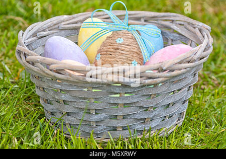 Close-up of a wooden basket full of colorful Easter eggs. Traditional hand-painted eggs for Easter celebration. Concept for Easter and spring Stock Photo