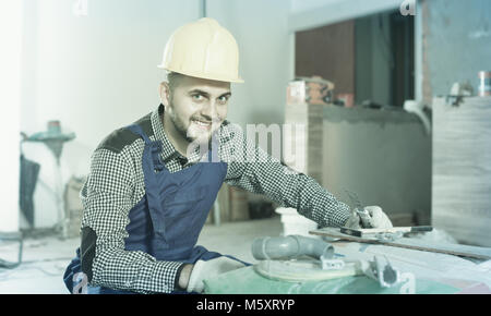 Diligent serious male worker is preparing for repair in the room at object Stock Photo