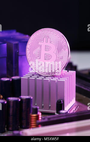 Photo of bitcoin and processor on pink background Stock Photo