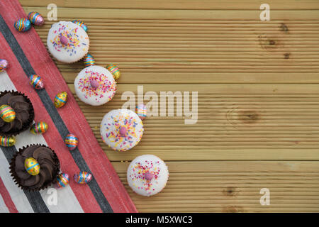 bright colorful Easter cakes on rustic wood table Stock Photo