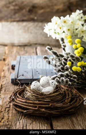 Easter eggs on wood. Colorful Easter holiday concept with  eggs in wisker basket in nature Stock Photo