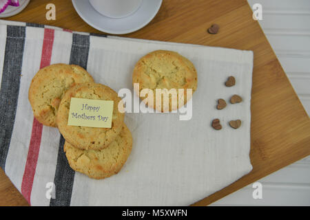 happy mothers day words on a note with homemade baked cookies or biscuits Stock Photo