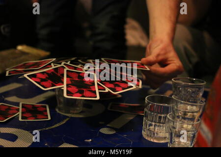 The "mushroom" drinking game in which cards must be balanced on a glass full of liquor, forming a mushroom cap. Stock Photo