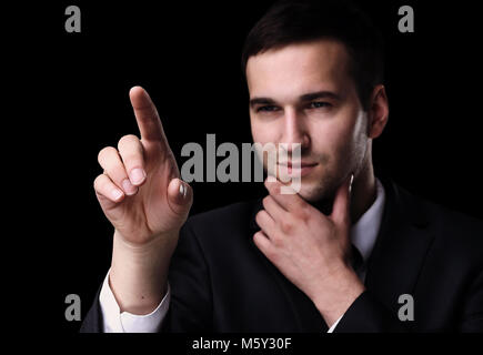Business man pushing the imaginary  button. Isoladed on black. Stock Photo