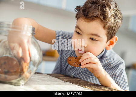 Smiling little boy eating some cookies Stock Photo