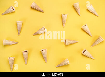 Top view of mini waffle cones on yellow background Stock Photo