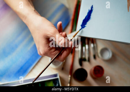 The process of creating an illustration by the artist. Watercolor paint.Hand with brush Stock Photo