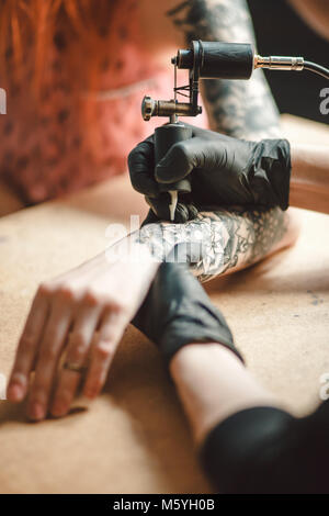tattoo artist makes tattoo Stock Photo