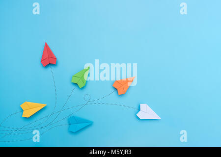 Color paper airplanes on blue background. Stock Photo