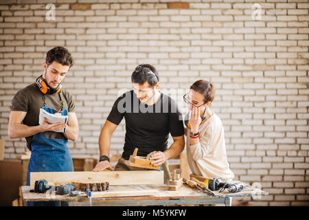 carpenter with students in woodworking workshop Stock Photo