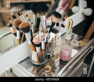 Make-up brushes and cosmetic on dressing table Stock Photo