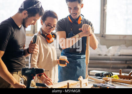 Carpenter Training Female Apprentice To Use Plane Stock Photo