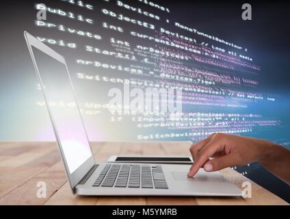 Hand using laptop with coding text Stock Photo