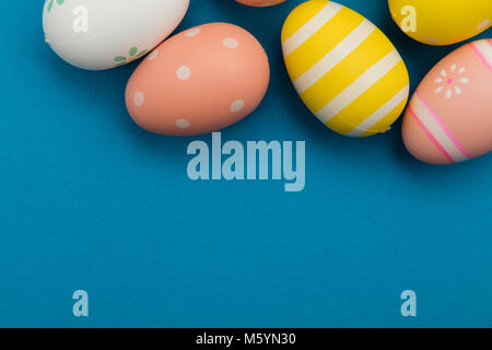 Easter holiday background. Pastel colored decorated easter eggs on a bright blue background Stock Photo