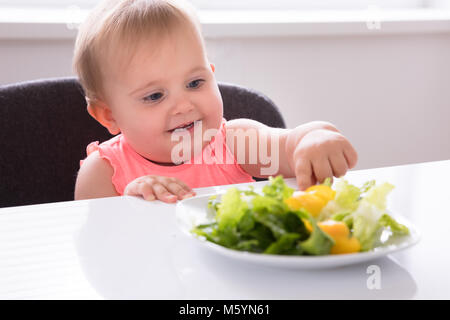 Close-up Of A Cute Baby Girl Eating Vegetable Stock Photo