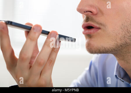 Close-up Of A Businessman Using Voice Assistant On Mobile Phone Stock Photo