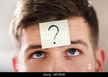 Close-up Of A Businessperson's Forehead With Question Mark On Sticky Note Stock Photo