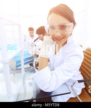 Investigator checking test tubes, Woman wears protective goggles Stock Photo