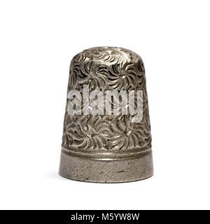 Metal sewing thimble on a finger white background Stock Photo