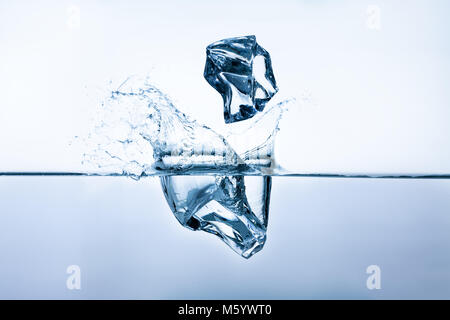 Two ice cubes splashing into clear water, closeup, frontview Stock Photo