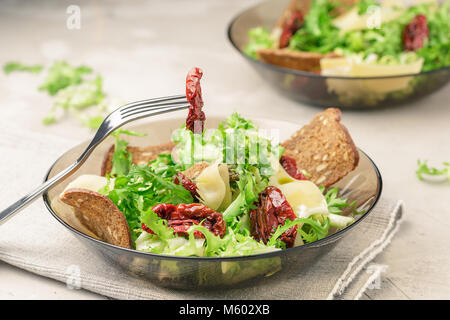 Salad with frisee lettuce, sun dried tomatoes, cheese and bread chips Stock Photo