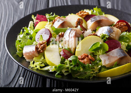 Fresh mackerel salad with apples, walnuts, beets and mix lettuce close-up on a plate on the table. horizontal Stock Photo