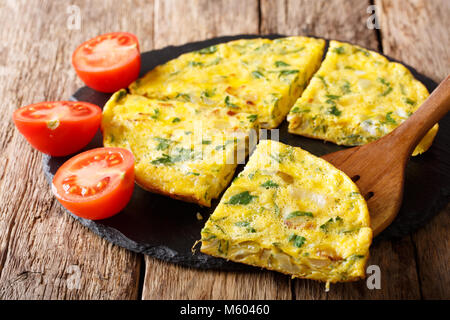 Homemade sliced scrambled eggs with greens, onions closeup on a table. horizontal Stock Photo