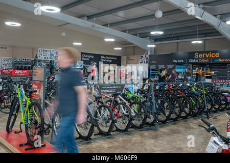 a real person stands in a halfords retail shop in a retail park in the bicycle department. Stock Photo