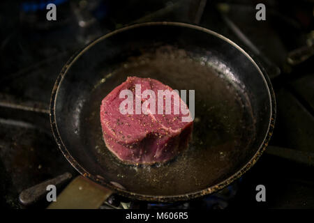 Man Cooks Meat In A Frying Pan Hand Using Spatula To Stir Red And