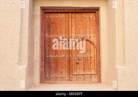 A traditional Arabian 'door within a door' in a building in in Al Ain, in the emirate of Abu Dhabi, United Arab Emirates. Stock Photo