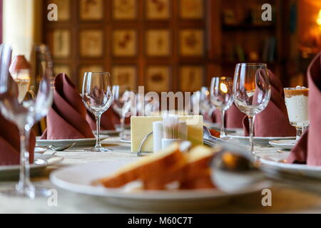 Table setting before the event. Willingness to receive guests. Perspective and lines, neatly before filing. Empty glasses and plates. There are snacks Stock Photo
