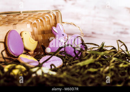 Beautiful glazed easter gingerbread cookies in a basket on wooden table. Rabbit and eggs. Greeting card. View from above.Copy space. Stock Photo