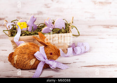 Beautiful glazed easter gingerbread cookies in a basket and rabbit on wooden table. Rabbit and egg. Greeting card. View from above.Copy space. Stock Photo