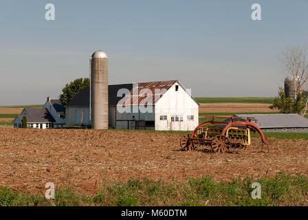 Old Amish farm and Old farm equipment on a Sunny Day with Blue Sky Stock Photo