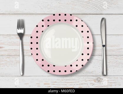 Top view of empty pink polka dot dish on wood table Stock Photo