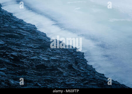 Beautiful frozen waterfall in central Norway. Winter landscape with a frozen river and ice formations. Stock Photo